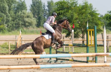 Genç adam ata biniyor.