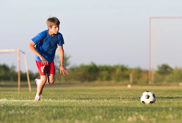 Chlapec hraje fotbal — Stock fotografie