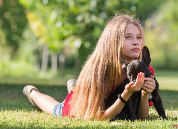 Jong meisje met Franse bulldog puppy — Stockfoto