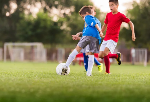 Meninos jogando futebol jogo no campo de esportes — Fotografia de Stock