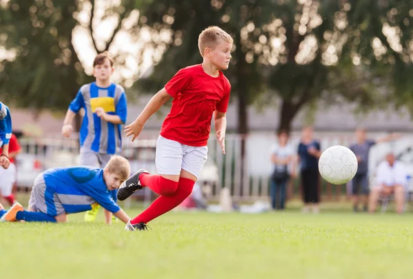 Meninos jogando futebol jogo no campo de esportes — Fotografia de Stock