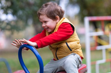 Çocuk parktaki testerede oynuyor.