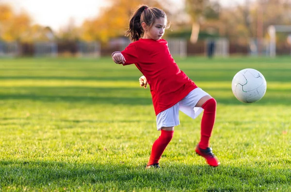 女の子はサッカー場でサッカーボールを蹴り — ストック写真