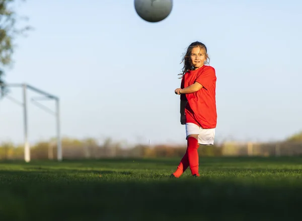 女の子はサッカー場でサッカーボールを蹴り — ストック写真