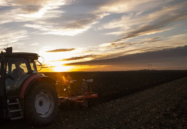 Traktor Membajak Lapangan Malam Hari Saat Matahari Terbenam — Stok Foto
