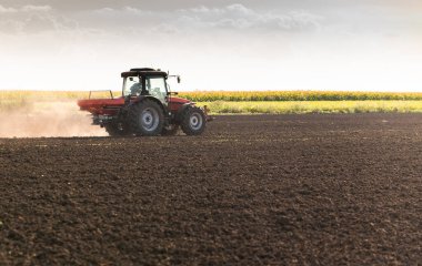Traktör yapay gübre yayıyor. Ulaşım, tarım.
