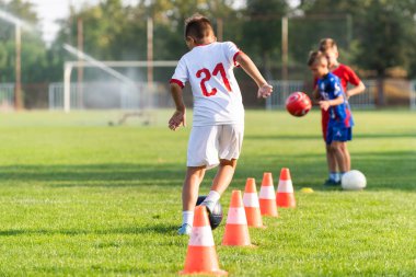 Çocuklar futbol sahasında birbirlerine pas atıyorlar.. 