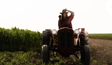 Tarlada traktör süren kadın çiftçi.