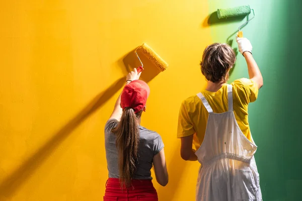 Pareja Joven Pintando Pared Verde Amarillo —  Fotos de Stock
