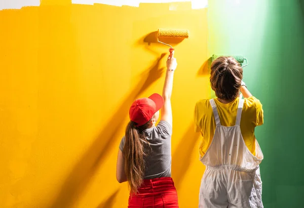 Pasangan Muda Mengecat Dinding Dengan Warna Hijau Dan Kuning — Stok Foto