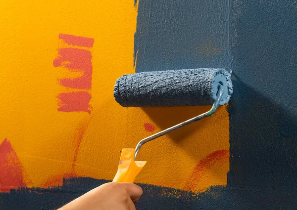 Tinta Azul Molhada Uma Parede Com Uma Mão Segurando Rolo — Fotografia de Stock