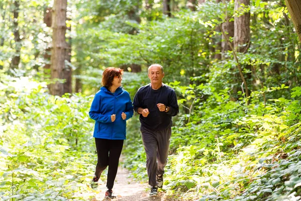 快乐的年长夫妇一起在公园里跑 — 图库照片