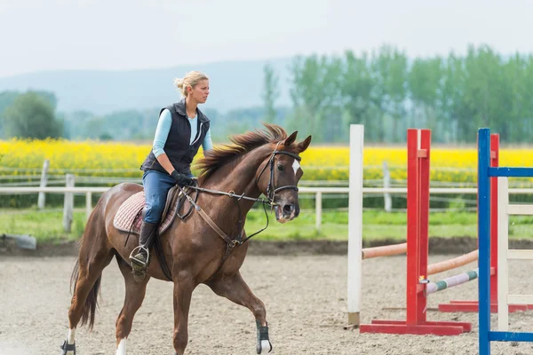 Mujer joven montando un caballo — Foto de Stock