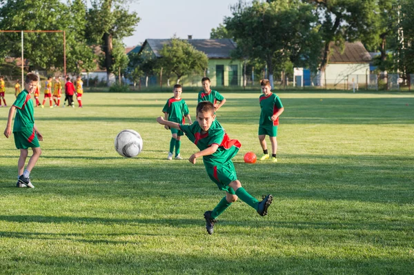 Jungen kicken Ball aufs Tor — Stockfoto