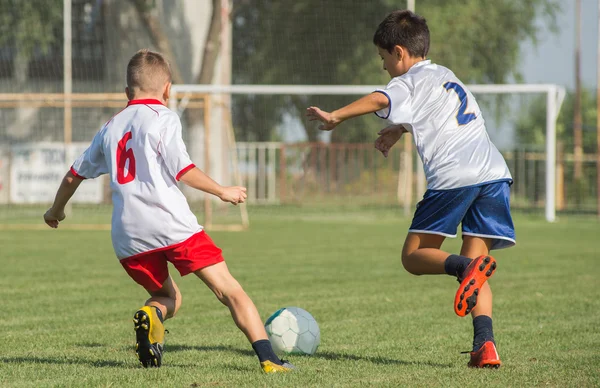 Мальчики пинают футбол — стоковое фото