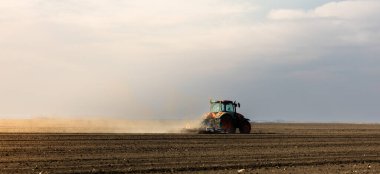 Traktör sürme çiftliği akşam yeni ekin ekimi için toprağı hazırlıyor..