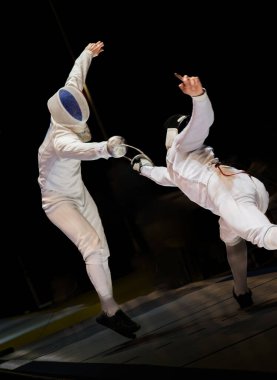 Eskrim yarışmasında dövüş. Profesyonel spor sahasında iki eskrim sporcusu kavga ediyor