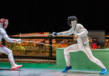 Eskrim yarışmasında dövüş. Profesyonel spor sahasında iki eskrim sporcusu kavga ediyor