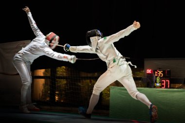 Eskrim yarışmasında dövüş. Profesyonel spor sahasında iki eskrim sporcusu kavga ediyor