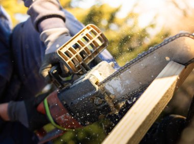 Sanayi inşaat işçisi elektrikli testere ile kereste kesiyor..