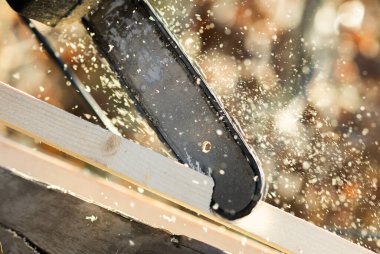 Sanayi inşaat işçisi elektrikli testere ile kereste kesiyor..