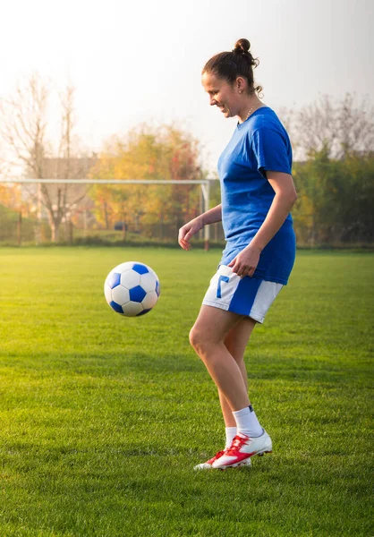 Kadın futbol tekmesi. Bir bayan futbolcu topa vuruyor..