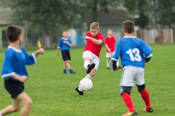 Junge kickt Fußball — Stockfoto