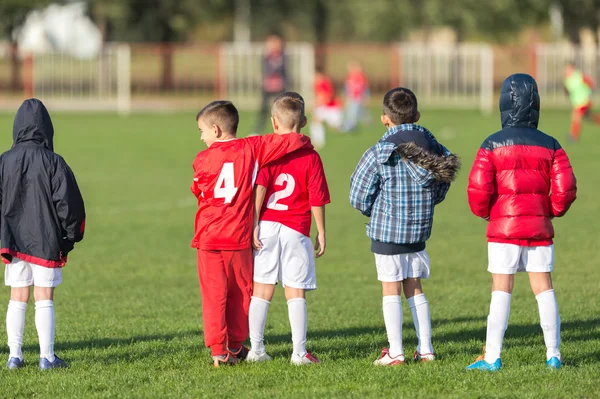 Giovane ragazzo guardando una partita di calcio per bambini — Foto Stock