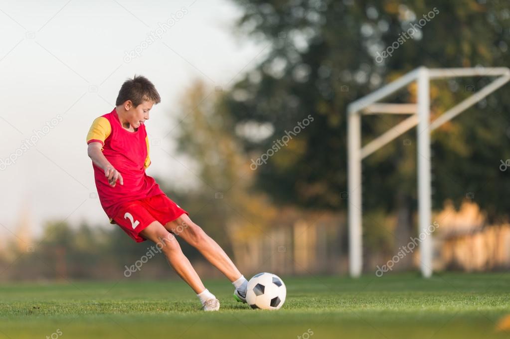 kid kicking a soccer ball