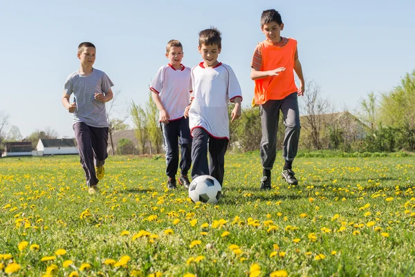 Meninos chutando futebol — Fotografia de Stock