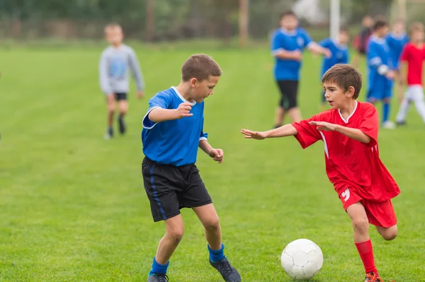 Мальчики пинают футбол — стоковое фото