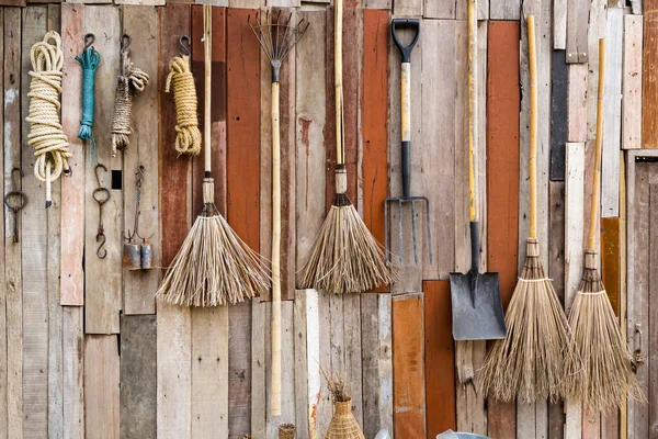 Rustic Farmhouse Wall Art , Vintage brooms and garden tools hanging on wood wall.