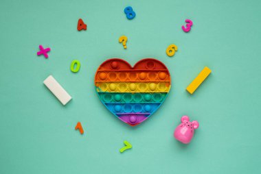 Çocuklar için renkli gökkuşağı kalbi şeklinde anti-stres oyuncağı. Patlat bakalım.