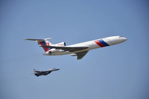 Sliac, Slovakia - August 27, 2011: Flight display of jet airliner Tupolev Tu-154M escorted by jet air fighter MiG-29 — Stock Photo, Image