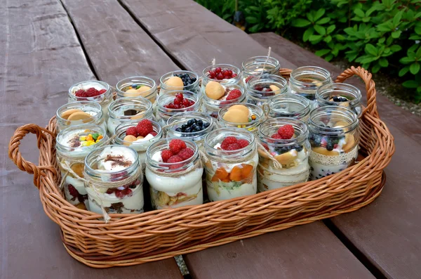 Dolce e sano dessert: tanti bicchieri pieni di crema e minuscoli frutti colorati — Foto Stock