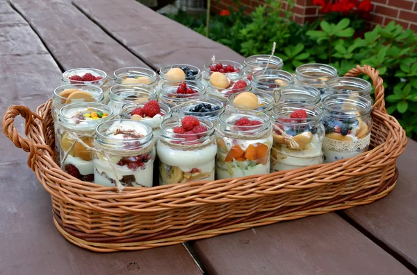 Dolce e sano dessert: tanti bicchieri pieni di crema e minuscoli frutti colorati — Foto Stock