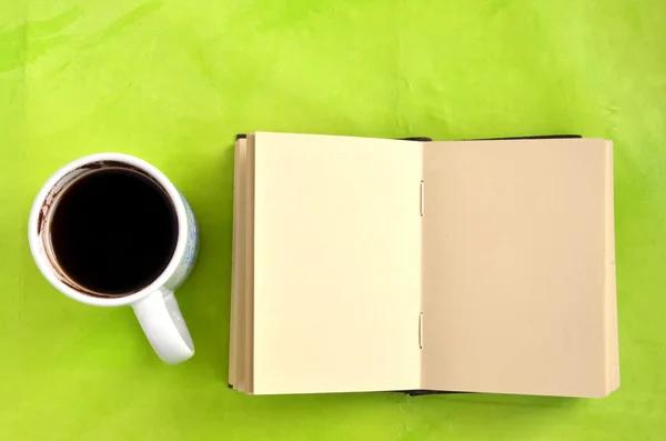 Fincan kahve ve kağıt defter yeşil zemin üzerine