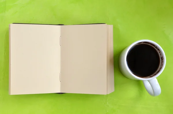 Fincan kahve ve kağıt defter yeşil zemin üzerine