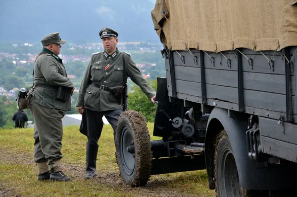 Historic truck with two men dressed in german nazi uniforms during historical reenactment of World War 2 battle — Stock Photo, Image