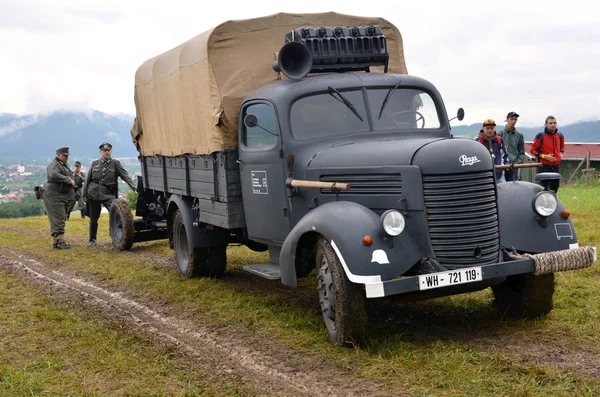 Historic truck with two men dressed in german nazi uniforms during historical reenactment of World War 2 battle — Stock Photo, Image
