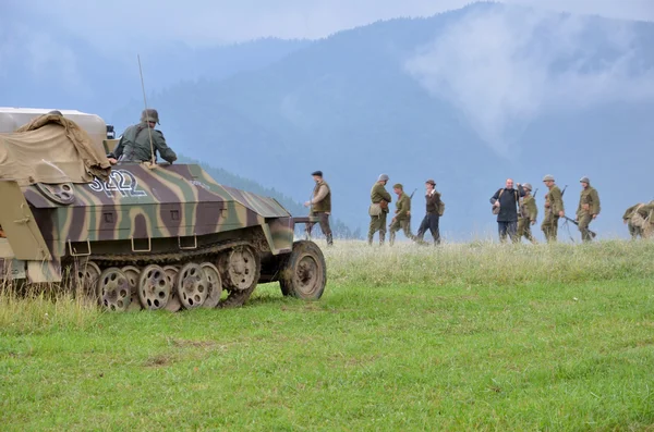 Historische re-enactment van World War 2 slag - gepantserde vervoermiddel en soldaten gekleed in Duitse nazi-uniformen — Stockfoto