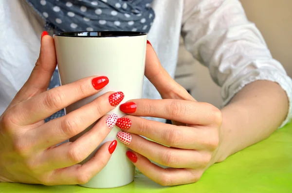 Girl with red nails on her fingers hold white cup, closeup — Stock Photo, Image