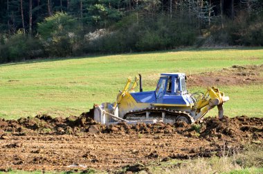 Sahada çalışan sarı mavi buldozer
