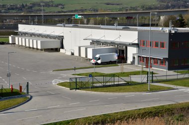 Modern Lojistik Merkezi, beyaz van ve römork altında bekleyen rampa