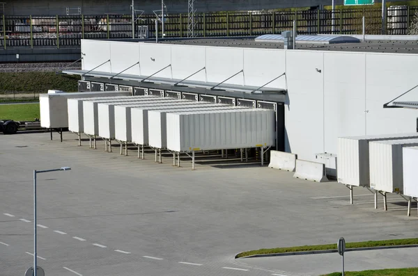 Cargo containers standing on gates in logistics center — Stock Photo, Image