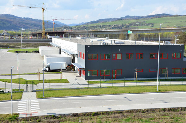 Logistics center, freight is uncharged from van. Tower cranes in background