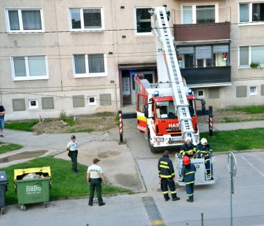 İtfaiyeciler eylem, gemiye teleskopik BOM sepet içine iki tane olsun. İki polis memuru yangın kamyon yanındaki stand