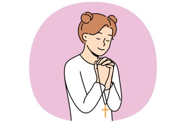 Küçük kız dua okur, avuçlarını göğsüne yakın uzatır ve Hıristiyan haçını elinde tutar. Genç yaşta dua eden, katoliklik ve Hıristiyan dinine bağlı hisseden mutlu çocuklar.