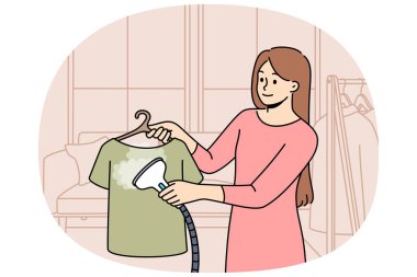 Kadın ev hanımı yıkadıktan sonra çamaşır yıkamak ve kırışıklıklardan kaçınmak için buhar ütüsü kullanır. Kız, ev işlerini kolaylaştıran ya da rutin aktivitelerde zaman ve efor tasarrufu sağlayan buhar ütüsünün çalışmalarını gösteriyor..