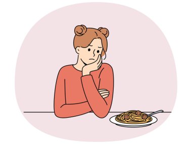 Kadının iştahı yok ve psikolojik sorunlar ve bulimia yüzünden bir tabak spagettiye bakıyor. Kızın iştahsızlığı sindirim bozukluklarına ve bulimiaya neden oluyor..